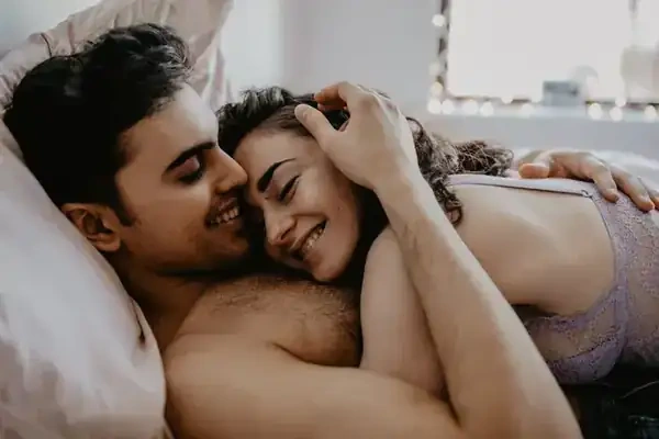 A couple lying together in bed, smiling, a stock lifestyle photograph